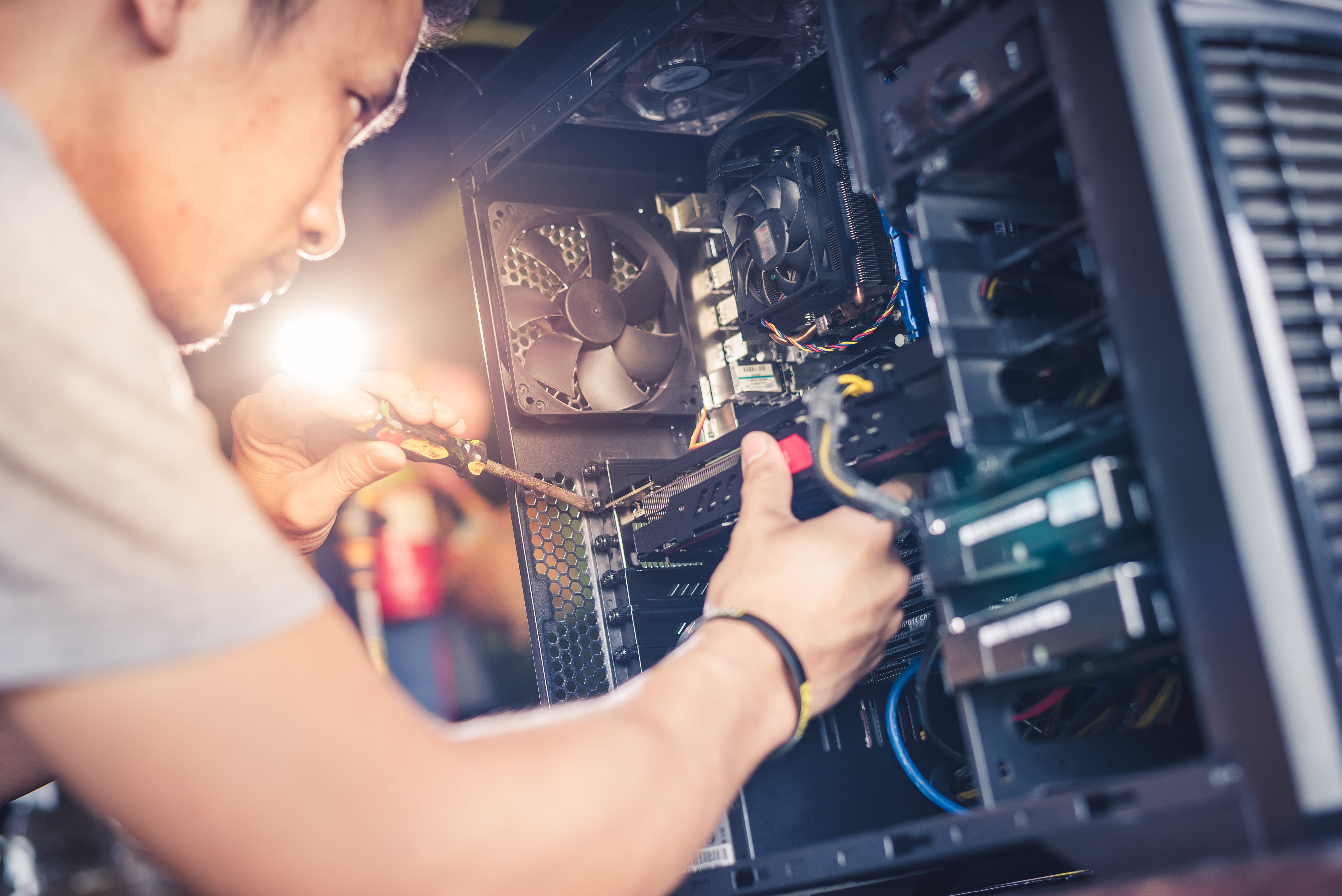 Technician repairing desktop hardware and internal computer components