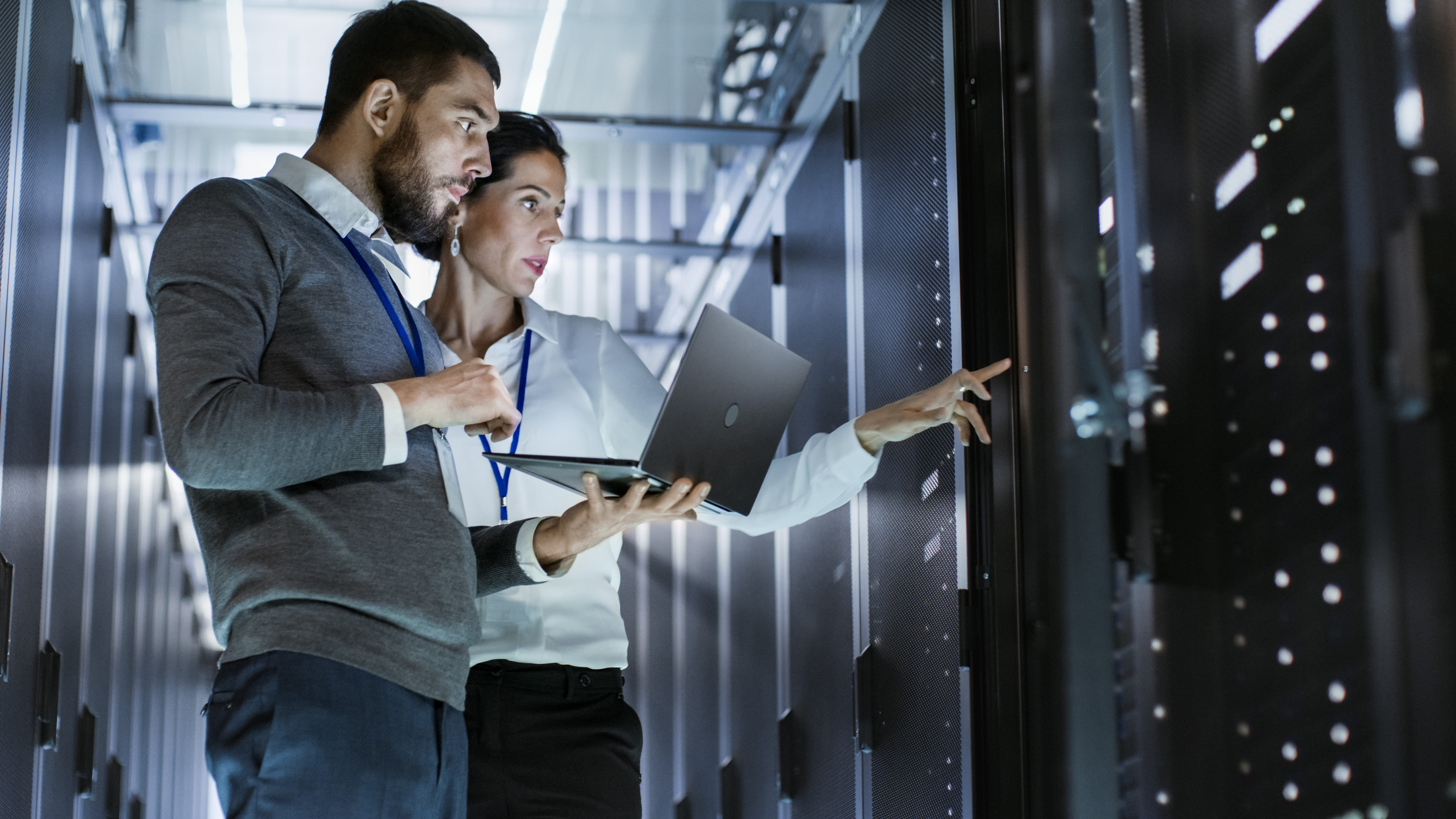 Technicians validating infrastructure and system performance in a server room